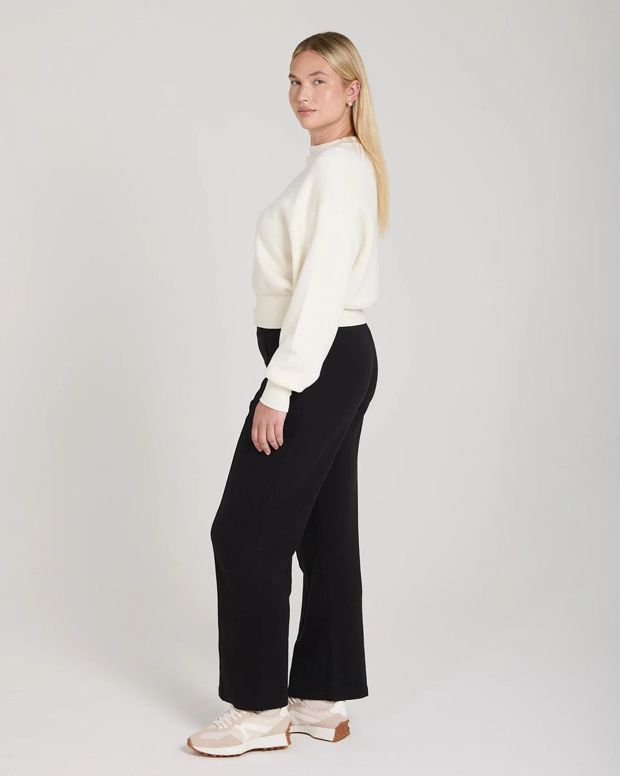 Model in cream sweatshirt with debossing, relaxed fit, crafted in sustainable lyocell.