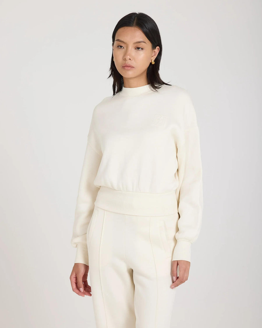 Model wearing cream sweatshirt with debossed logo, relaxed fit in luxurious lyocell.