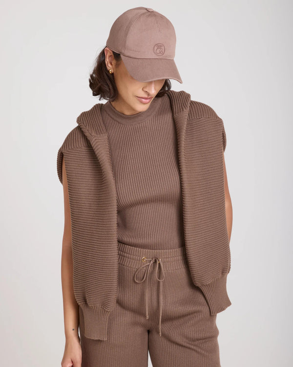 Emello Cap in taupe with elegant embroidery, worn by a model showcasing warm, tactile elegance.