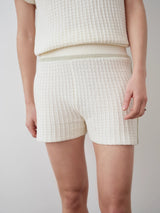 White textured knit shorts featuring a crochet-effect and contrast seams, crafted in breathable cotton.