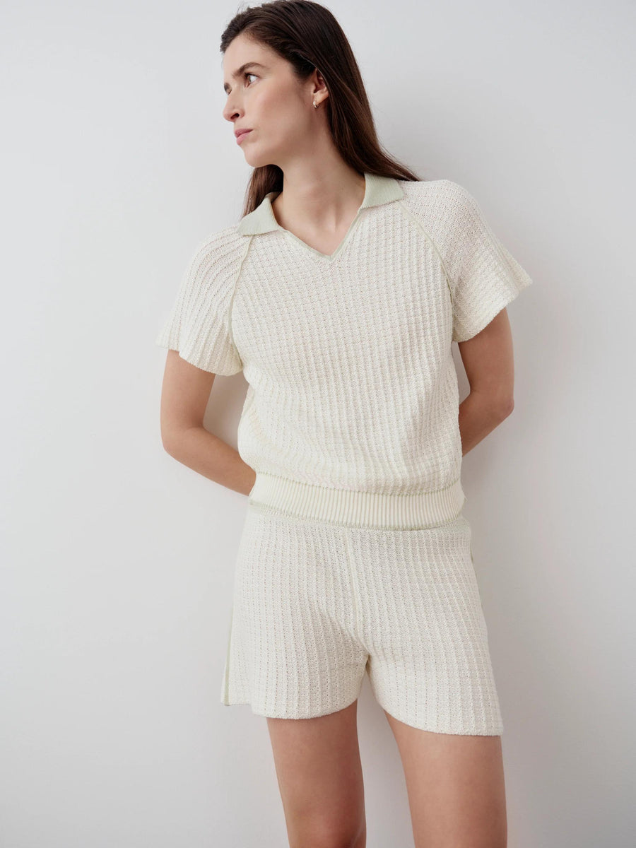 Model wearing Emello's luxury textured knit shorts in white, showcasing a softly fluted shape and fluid movement.