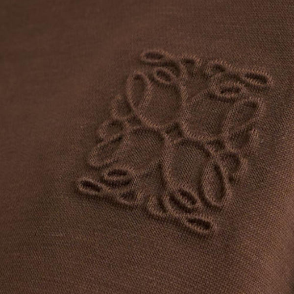 Close-up of tonal embroidery on fine chocolate brown knit fabric