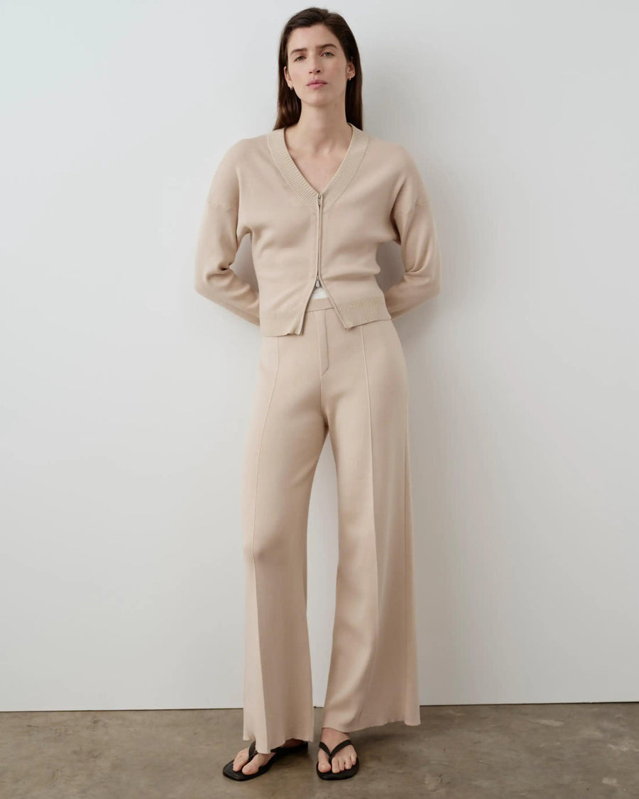Elegant model in double waistband knitted trousers by Emello, showcasing tactile elegance and refined tailoring.