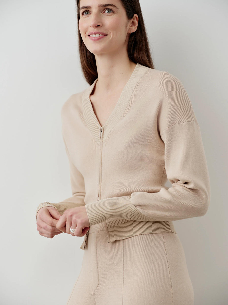 V-neck zip cardigan in neutral organic cotton with softly structured silhouette and brushed-metal zip.