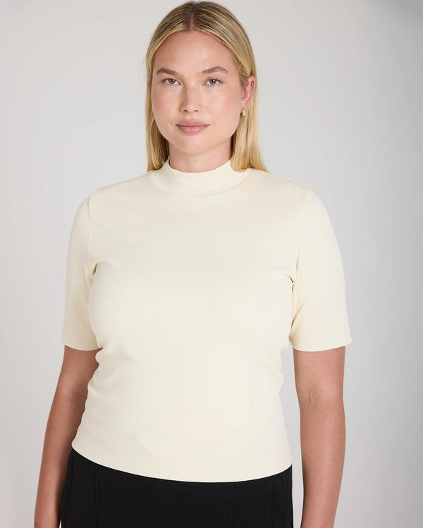 Cream double-layer high neck top in viscose showcased on model, embodying refined tactile elegance.