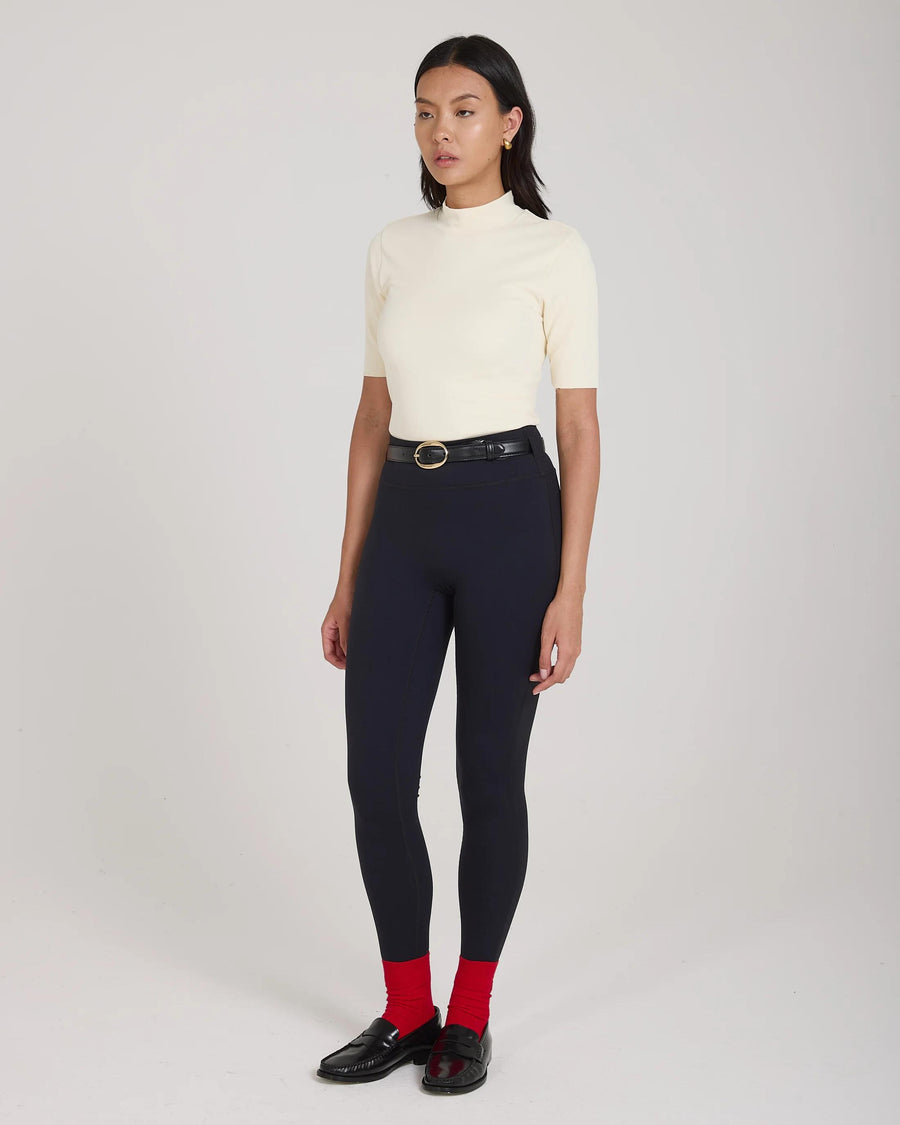 Elegant cream double layer high neck top in viscose, worn in a poised stance.