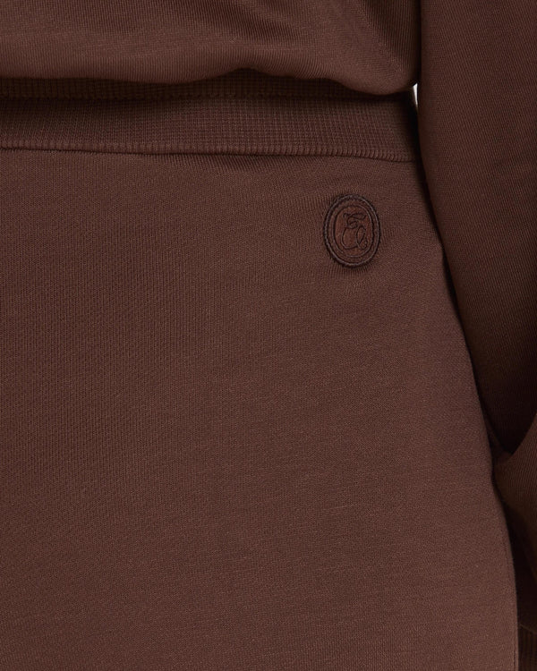 Close-up of chocolate brown Lyocell wide-leg pants with subtle embroidery, highlighting texture and refined detail.