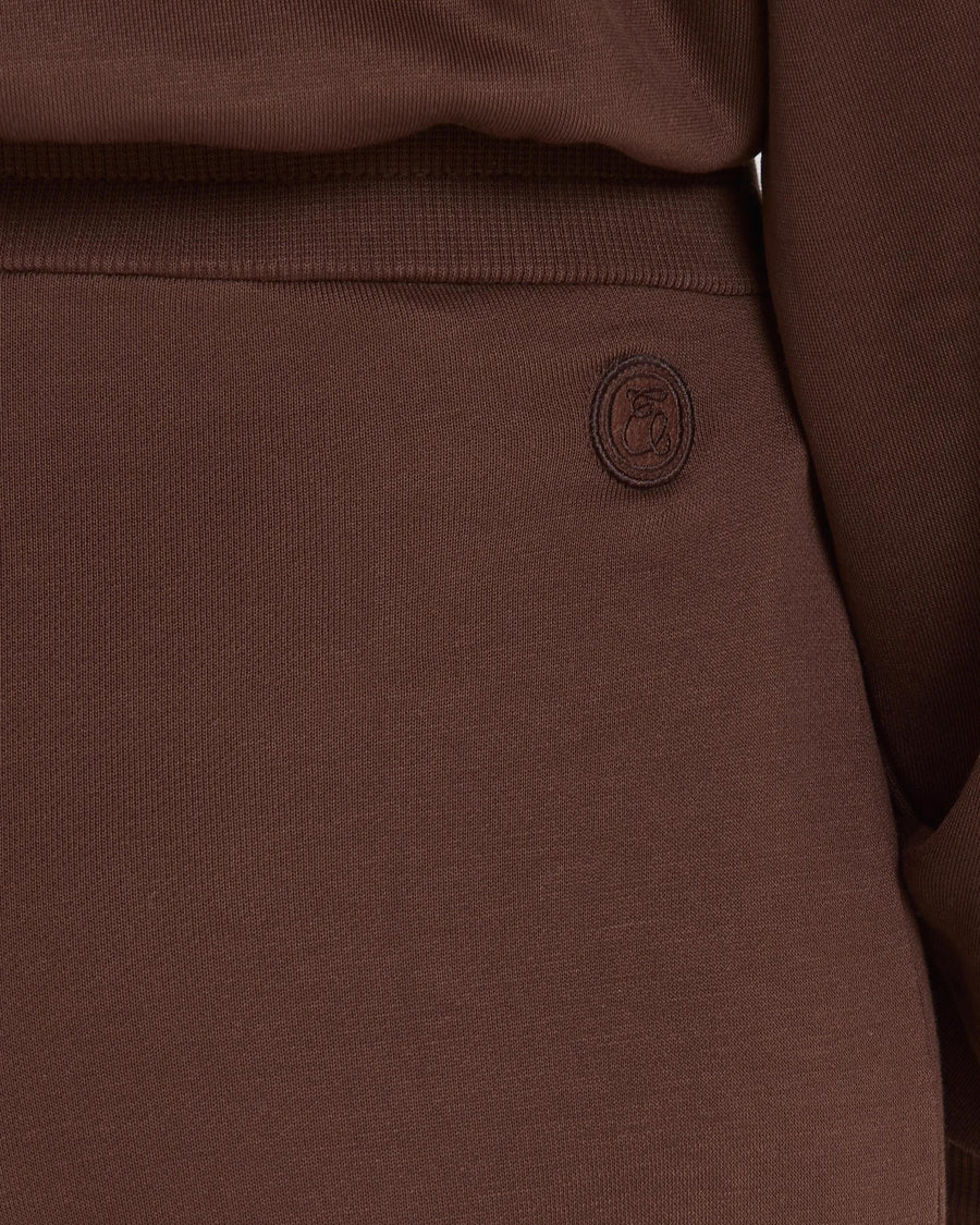 Close-up of chocolate brown Lyocell wide-leg pants with subtle embroidery, highlighting texture and refined detail.