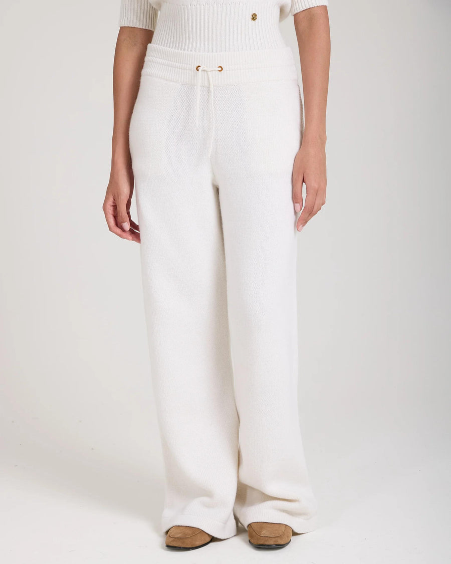 Cream wide leg trousers in merino wool cashmere blend with gold hardware and pockets.