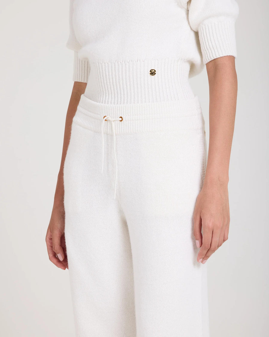 Cream wide leg trousers in merino wool and cashmere blend with gold hardware, worn by model