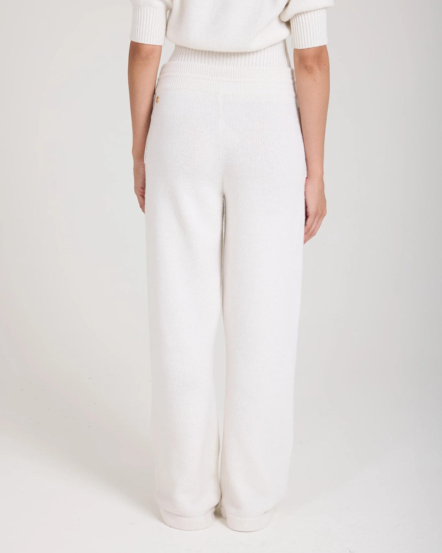 Back view of cream wide-leg trousers in a luxurious merino wool and cashmere blend, featuring ribbed waistband and gold hardware.