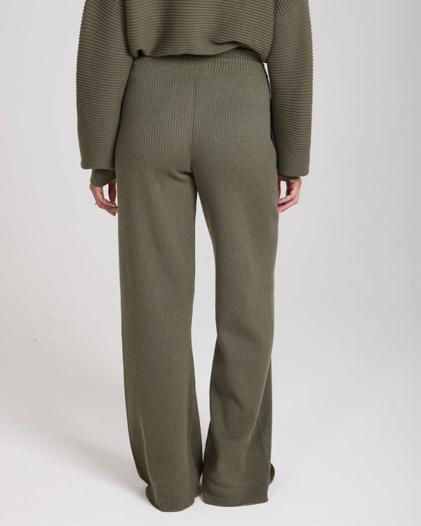 Olive ribbed wide-leg trousers with an elastic waistband, viewed from the back.