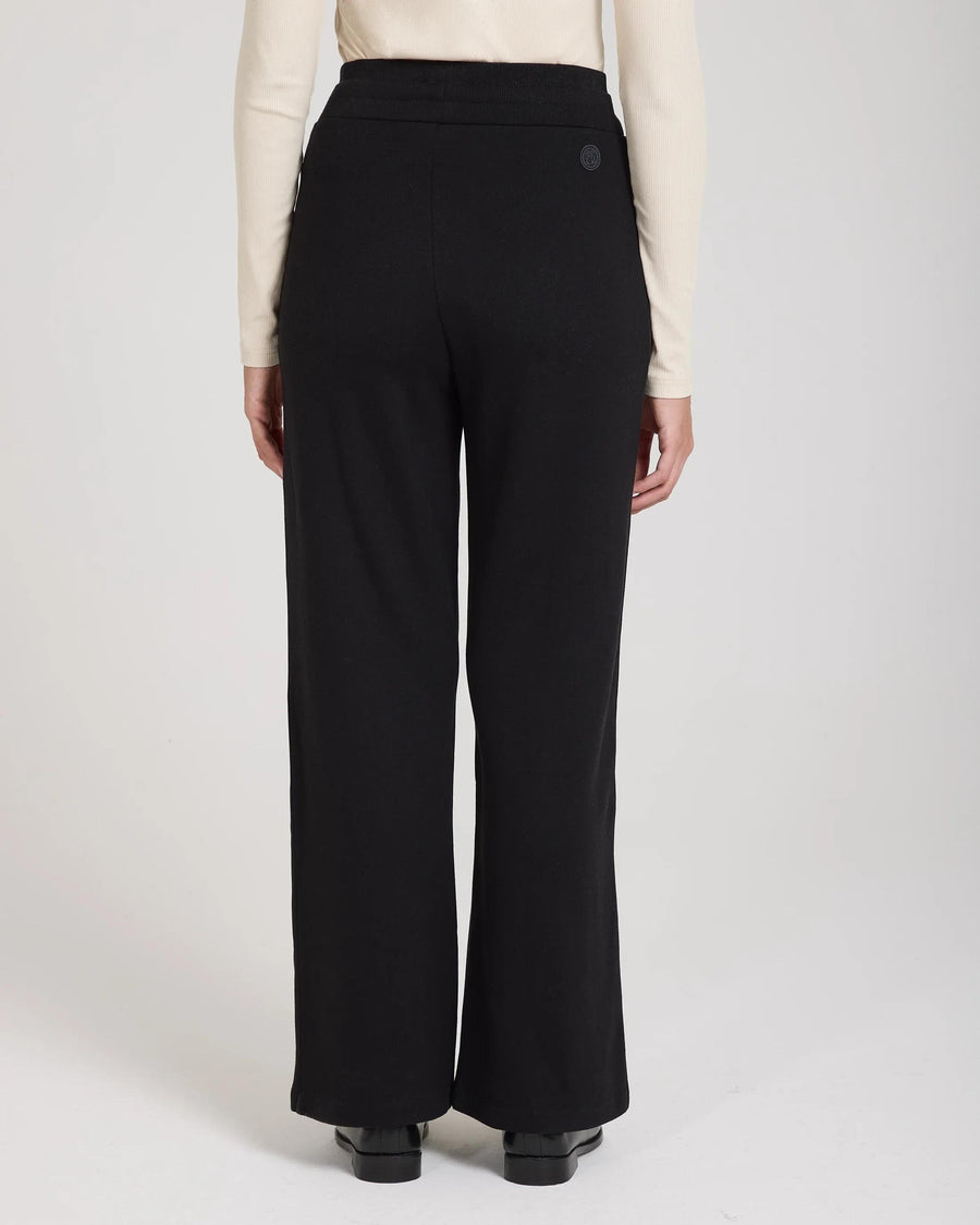 Back view of black wide-leg trousers in Lyocell with relaxed fit, double-layer waistband and embroidered badge.