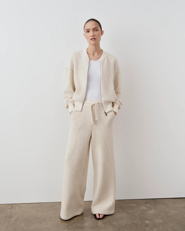 Model wearing Emello Stripe Knit Wide Leg Trousers in cream, styled with a matching jacket.