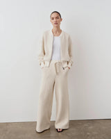 Model wearing Emello Stripe Knit Wide Leg Trousers in cream, styled with a matching jacket.